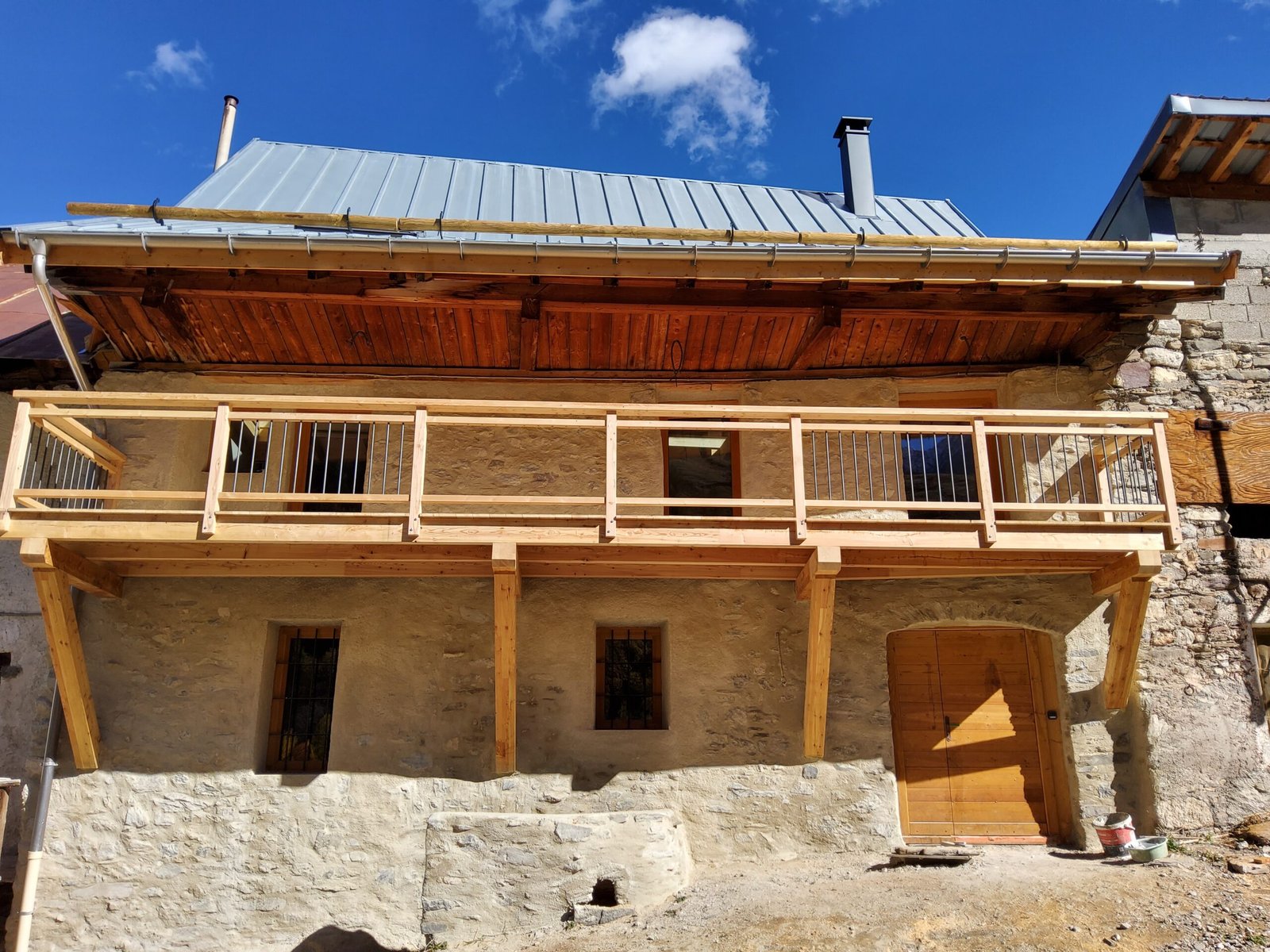 La façade de pierre et son balcon en bois