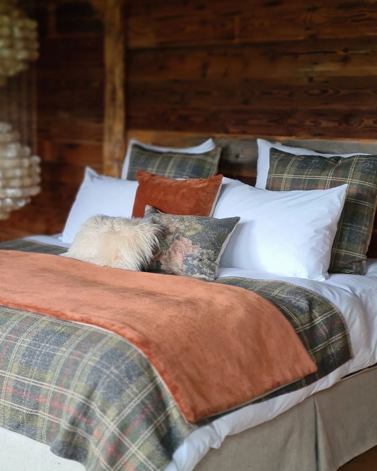 Habitación con madera, mantón de tartan y cojines